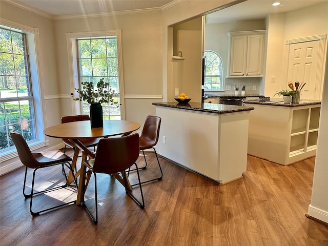 kitchen featuring a healthy amount of sunlight, white cabinetry, dark stone counters, and light hardwood / wood-style flooring