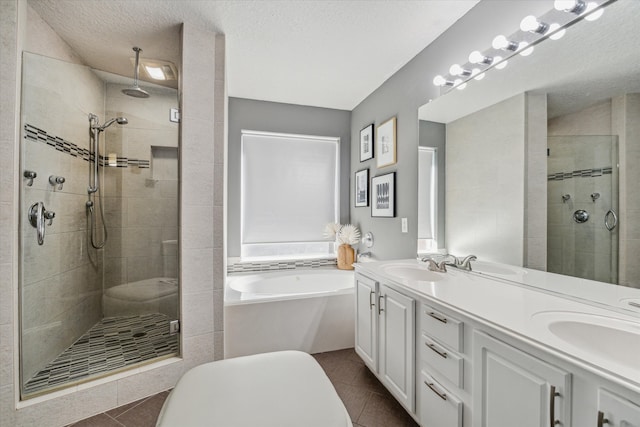 bathroom featuring tile patterned flooring, vanity, a textured ceiling, and plus walk in shower