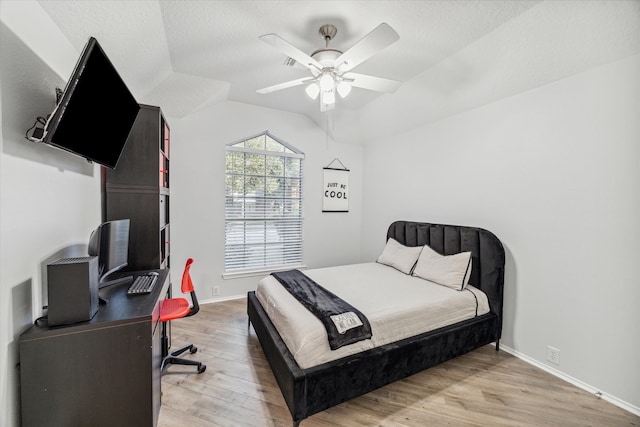 bedroom featuring hardwood / wood-style floors, a textured ceiling, vaulted ceiling, and ceiling fan