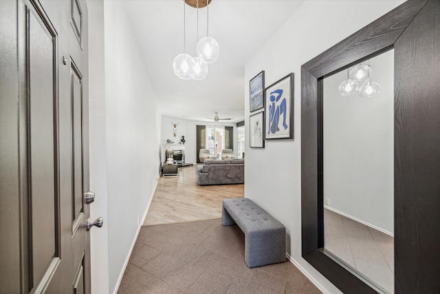 hallway featuring a chandelier and wood-type flooring