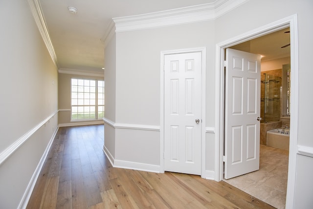 hall with crown molding and light wood-type flooring