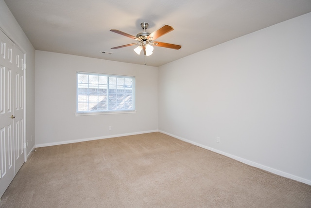 carpeted spare room with ceiling fan