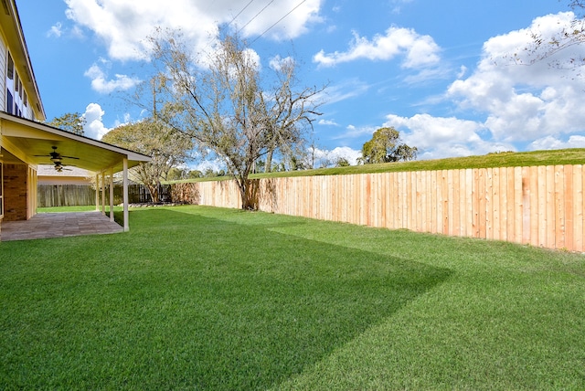 view of yard with ceiling fan and a patio area