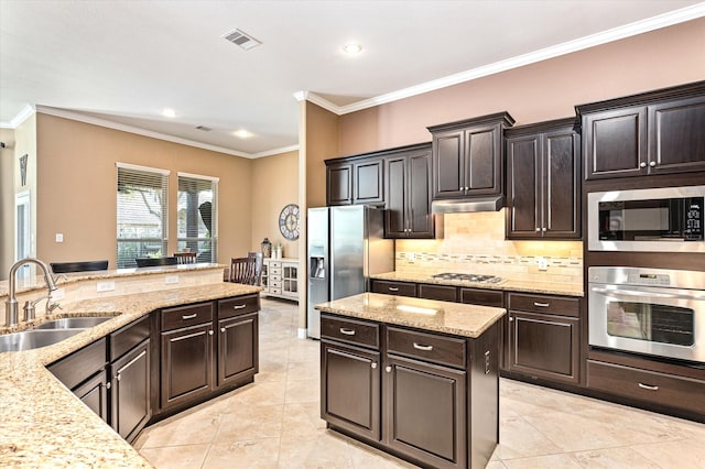 kitchen featuring sink, stainless steel appliances, light stone counters, crown molding, and dark brown cabinets