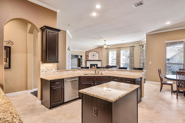 kitchen featuring dishwasher, a kitchen island, light stone countertops, and ornamental molding