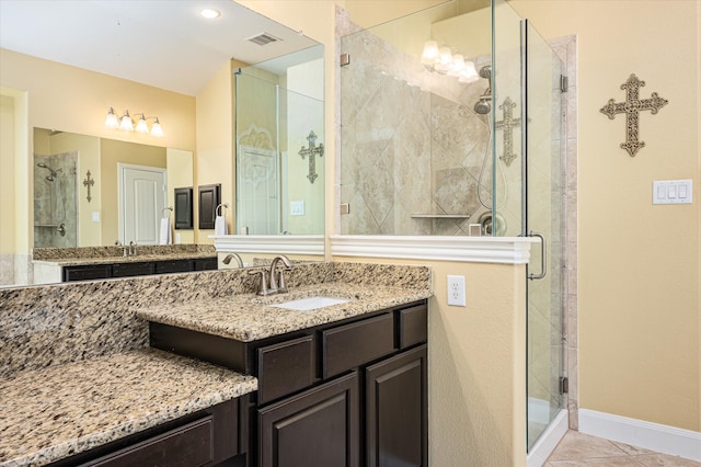 bathroom with tile patterned floors, a shower with door, and vanity