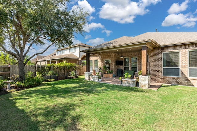 rear view of property with a lawn, ceiling fan, and a patio