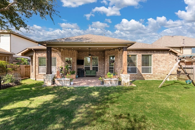 back of property featuring a yard, ceiling fan, and a patio area