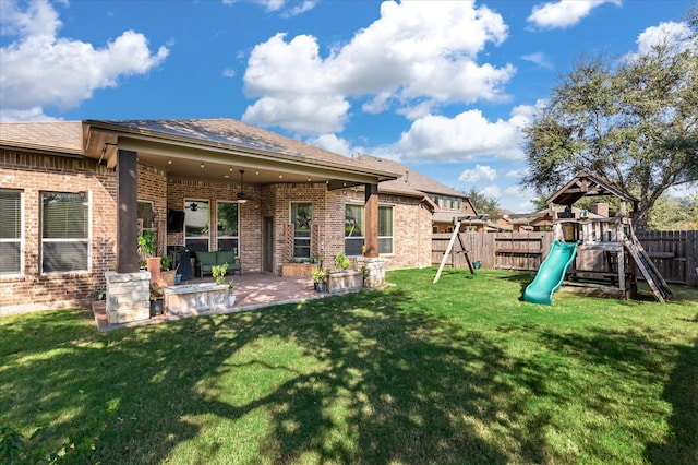 back of property featuring a playground, a lawn, and a patio