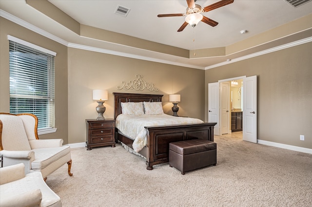 bedroom with a raised ceiling, connected bathroom, ceiling fan, and light colored carpet