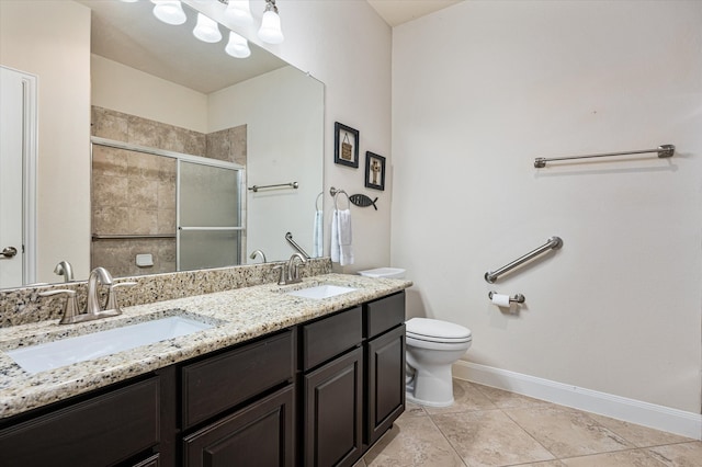 bathroom with tile patterned flooring, vanity, a shower with shower door, and toilet