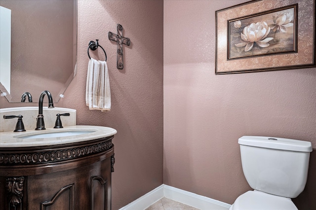 bathroom with tile patterned flooring, vanity, and toilet