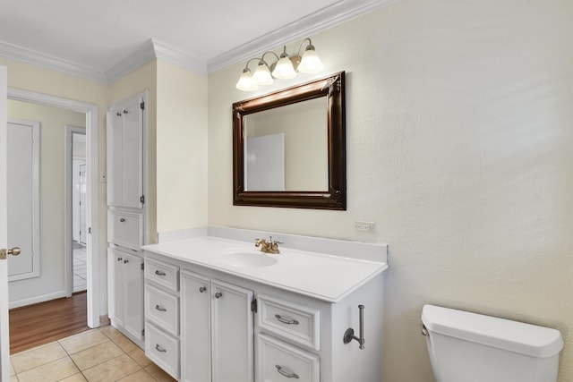 bathroom featuring tile patterned flooring, vanity, toilet, and crown molding