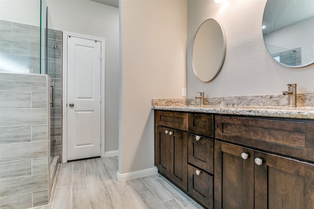 bathroom featuring vanity, wood-type flooring, and a shower with shower door