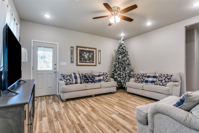 living room with light hardwood / wood-style floors and ceiling fan