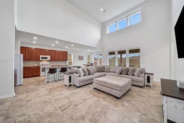 living room featuring a healthy amount of sunlight and a towering ceiling