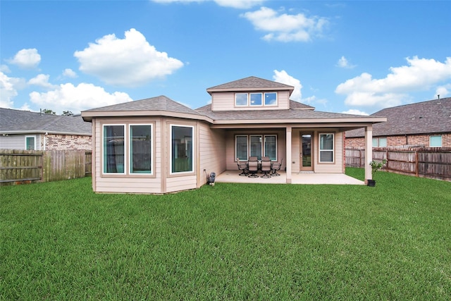 rear view of house featuring a lawn and a patio area