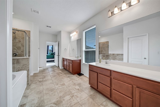 bathroom with vanity, separate shower and tub, and a textured ceiling