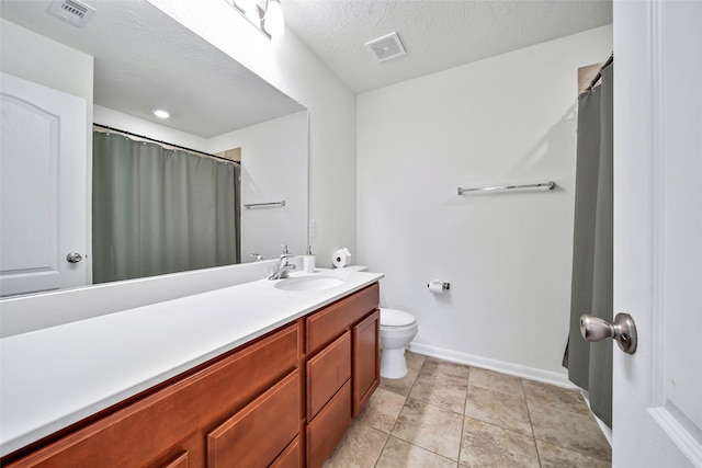 bathroom with tile patterned floors, vanity, toilet, and a textured ceiling