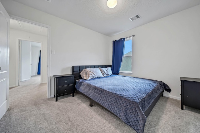 bedroom featuring a textured ceiling and light colored carpet