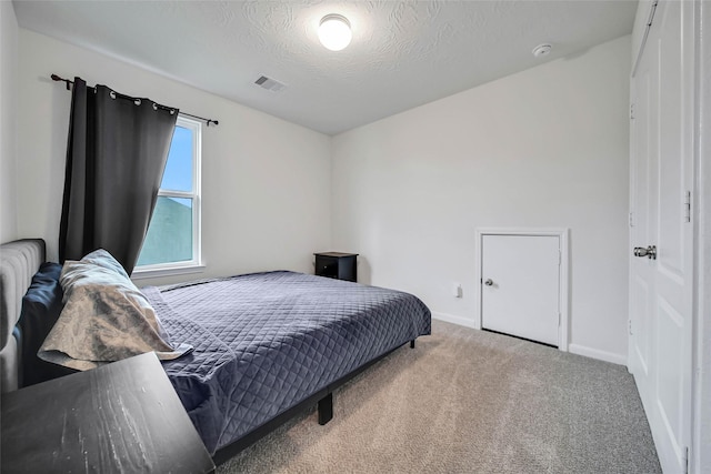 bedroom with carpet and a textured ceiling