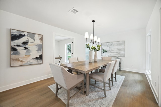 dining area featuring a chandelier and dark hardwood / wood-style floors