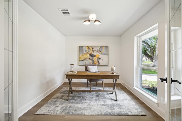 home office with dark wood-type flooring and a healthy amount of sunlight