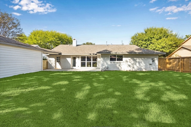 back of house with a lawn and a patio area