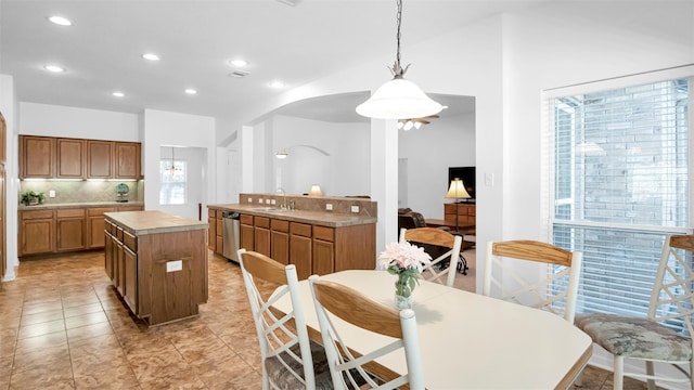 kitchen with decorative backsplash, a wealth of natural light, sink, and decorative light fixtures