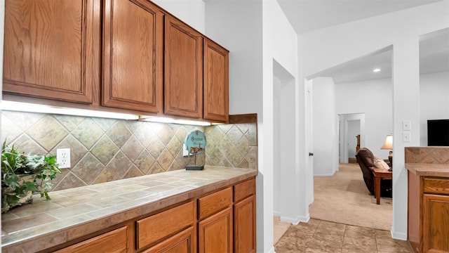 kitchen featuring backsplash, tile countertops, and light carpet