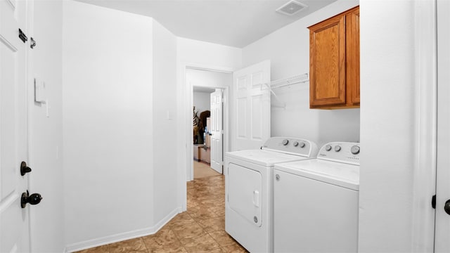 laundry room featuring cabinets, light tile patterned floors, and washing machine and clothes dryer