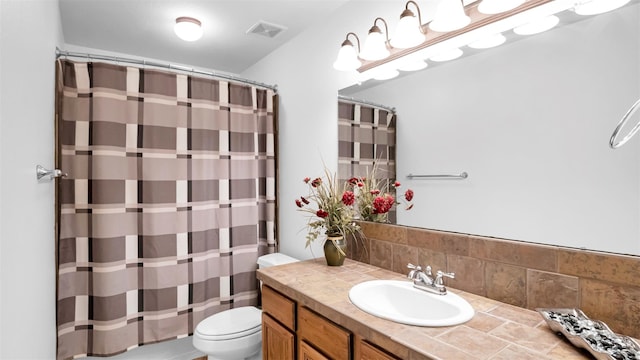 bathroom with vanity, toilet, backsplash, and walk in shower