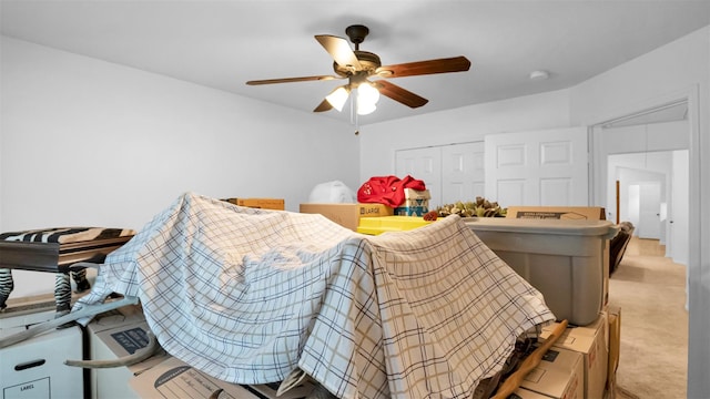 carpeted bedroom featuring ceiling fan and a closet