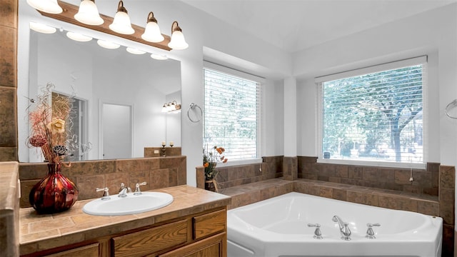 bathroom featuring vanity, lofted ceiling, and a bath