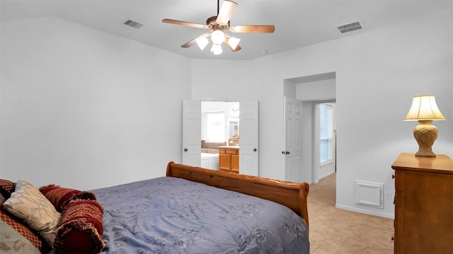 carpeted bedroom with ceiling fan, ensuite bathroom, and vaulted ceiling