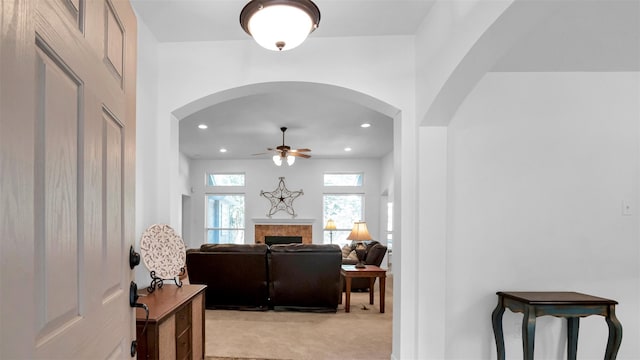 carpeted living room with ceiling fan