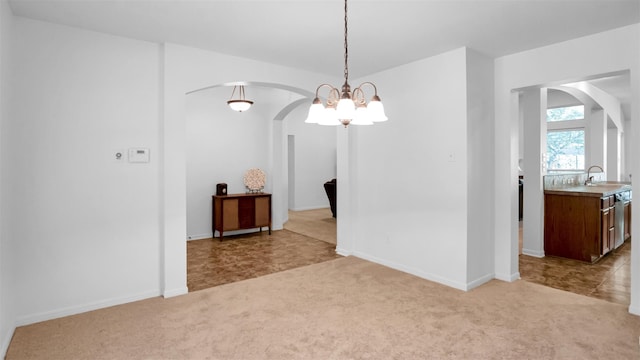 unfurnished dining area featuring a chandelier, sink, and light colored carpet