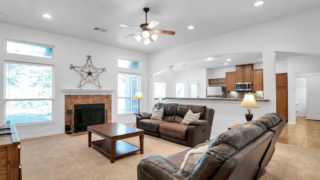 living room with a tile fireplace, light colored carpet, and a healthy amount of sunlight