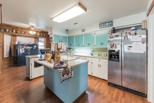 kitchen featuring stainless steel refrigerator with ice dispenser, ceiling fan, light hardwood / wood-style flooring, a center island, and white cabinetry