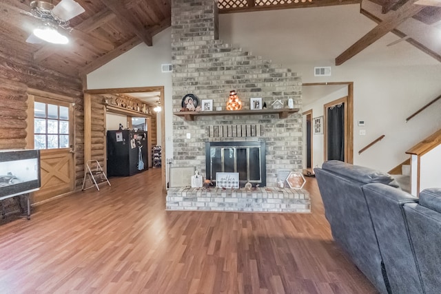 unfurnished living room with vaulted ceiling with beams, ceiling fan, a fireplace, and hardwood / wood-style flooring