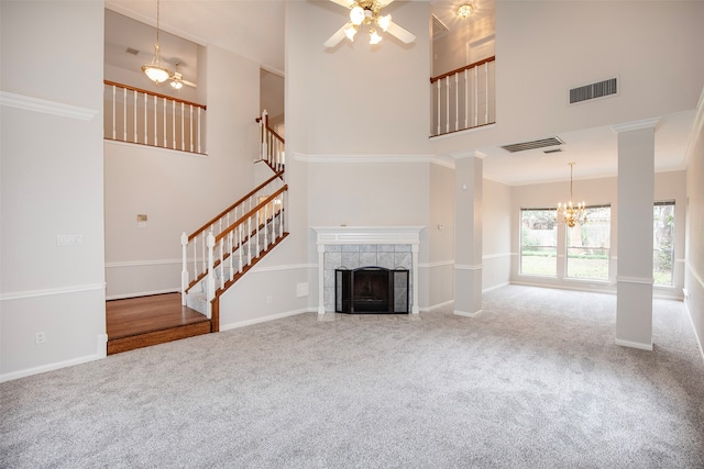 unfurnished living room featuring carpet flooring, ceiling fan, a high ceiling, a tiled fireplace, and ornamental molding