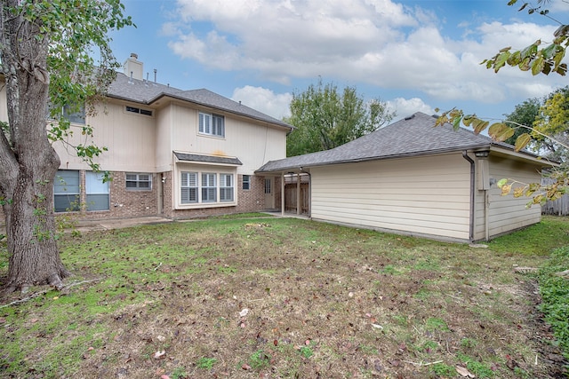 back of house with a lawn