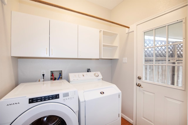 laundry room with separate washer and dryer and cabinets