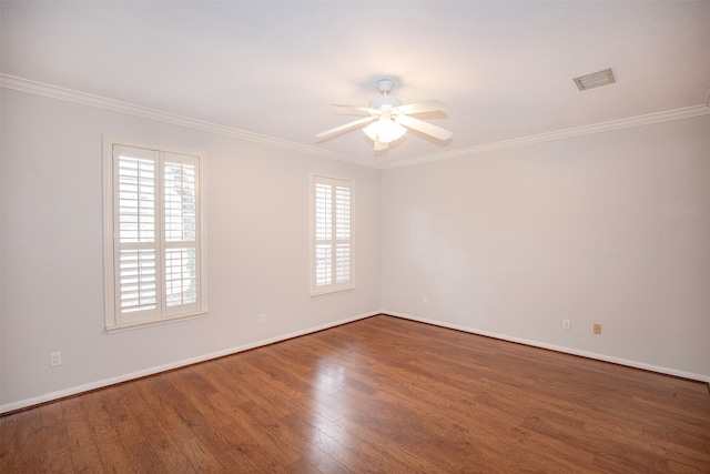 spare room featuring dark hardwood / wood-style floors, a wealth of natural light, ornamental molding, and ceiling fan