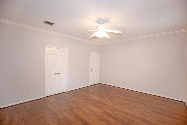 spare room with ceiling fan, crown molding, and dark wood-type flooring