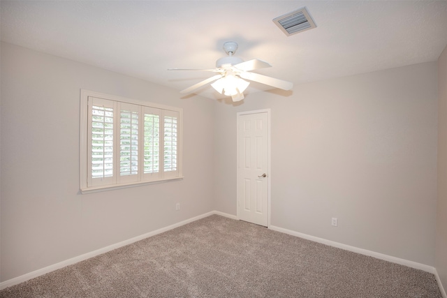 carpeted spare room featuring ceiling fan