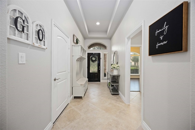 interior space with light tile patterned floors and a raised ceiling