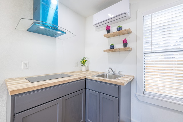 kitchen featuring butcher block counters, sink, a healthy amount of sunlight, a wall unit AC, and island range hood