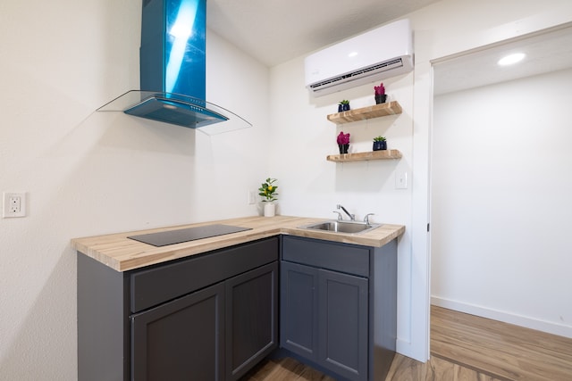 kitchen with black electric stovetop, ventilation hood, dark wood-type flooring, sink, and an AC wall unit