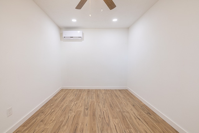 spare room featuring ceiling fan, light hardwood / wood-style floors, and a wall mounted air conditioner